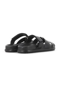 Sandalias de cuero negro con dos correas anchas, punta abierta y soporte en la parte posterior. La suela de goma texturizada cuenta con ranuras para un mejor agarre.