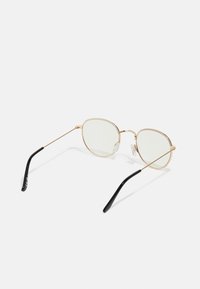 Gold metal-frame sunglasses with light green lenses, oval shape, clear nose pads, and black plastic temple tips for comfort.