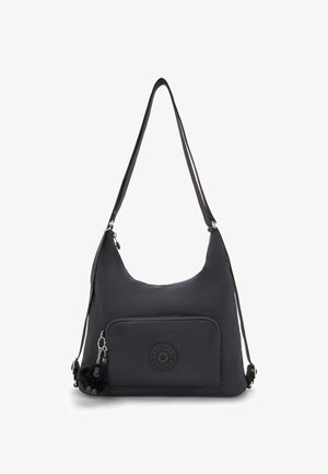 Sort skuldertaske med frontlomme med lynlås, Kipling-logo og lille pelsnøglering hængt på lynlåspulleren.