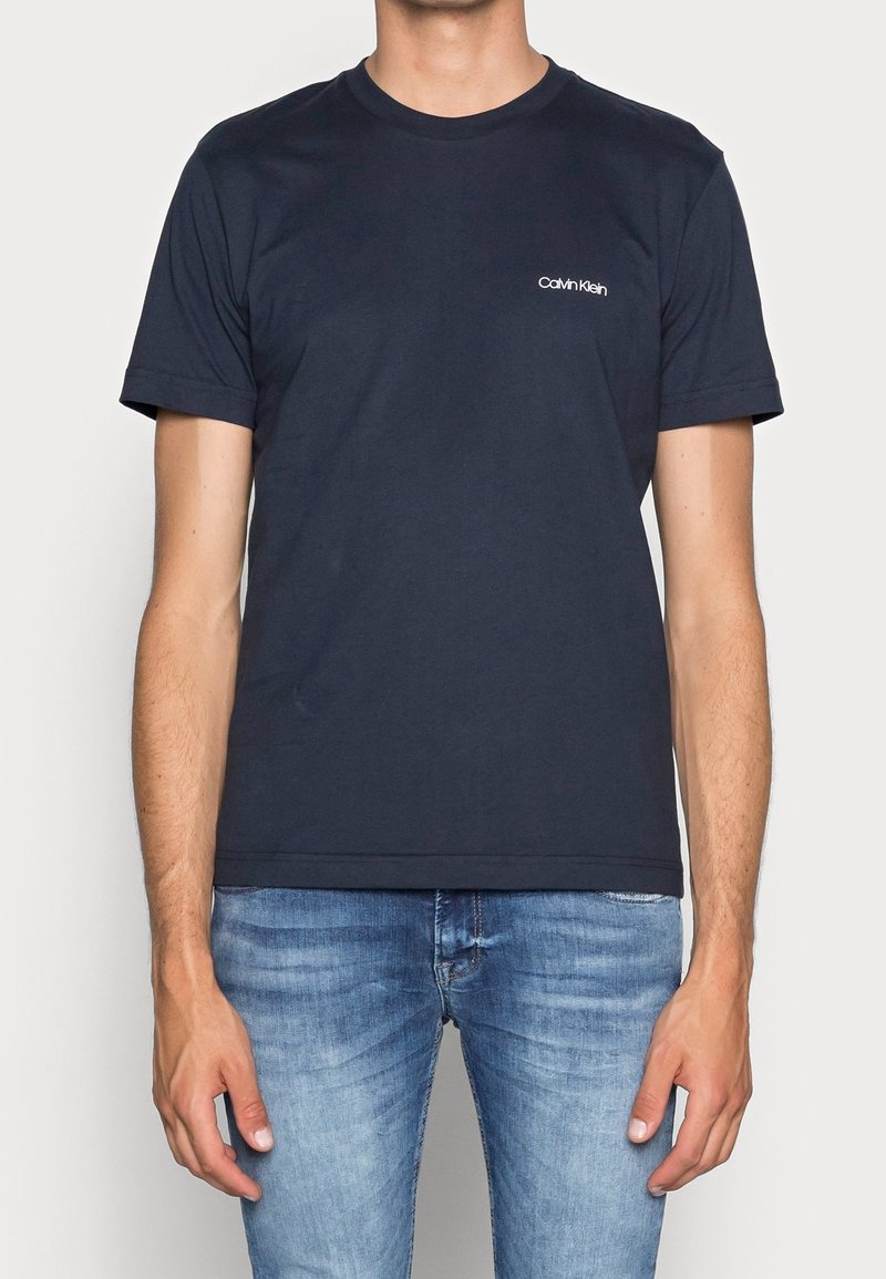 Navyblauwe katoenen T-shirt met korte mouwen en een ronde hals, voorzien van een klein wit Calvin Klein-logo op de linkerborst.