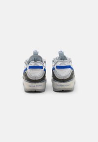 Sportskor med grå bas, blå accenter, slät textur, dragflik och genomskinliga sulor märkta "CRATER FOAM."