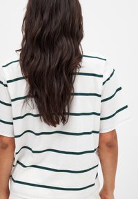 Vitt kortärmat t-shirt med gröna och mörkgröna horisontella ränder, med en mjuk textur och avslappnad passform, sedd bakifrån.