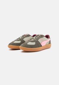 Zapatillas deportivas con parte superior de ante gris y verde oliva, acentos en rosa, punta redonda y suela de goma. Cuenta con cordones y cuello acolchado.