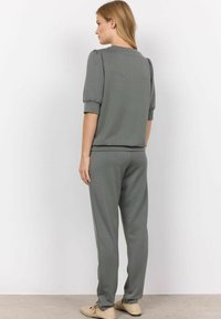 Set di abbigliamento comodo grigio chiaro composto da una maglietta a maniche corte con maniche a palloncino e pantaloni tapered coordinati. Tessuto morbido con una vestibilità rilassata.