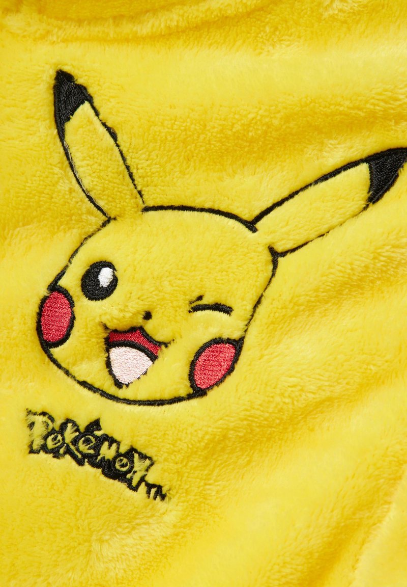 Gelbes Plüschgewebe mit einem gestickten Pikachu-Gesicht, schwarzen Akzenten, roten Wangen und dem Text "Pokémon" in Schwarz unter dem Bild.