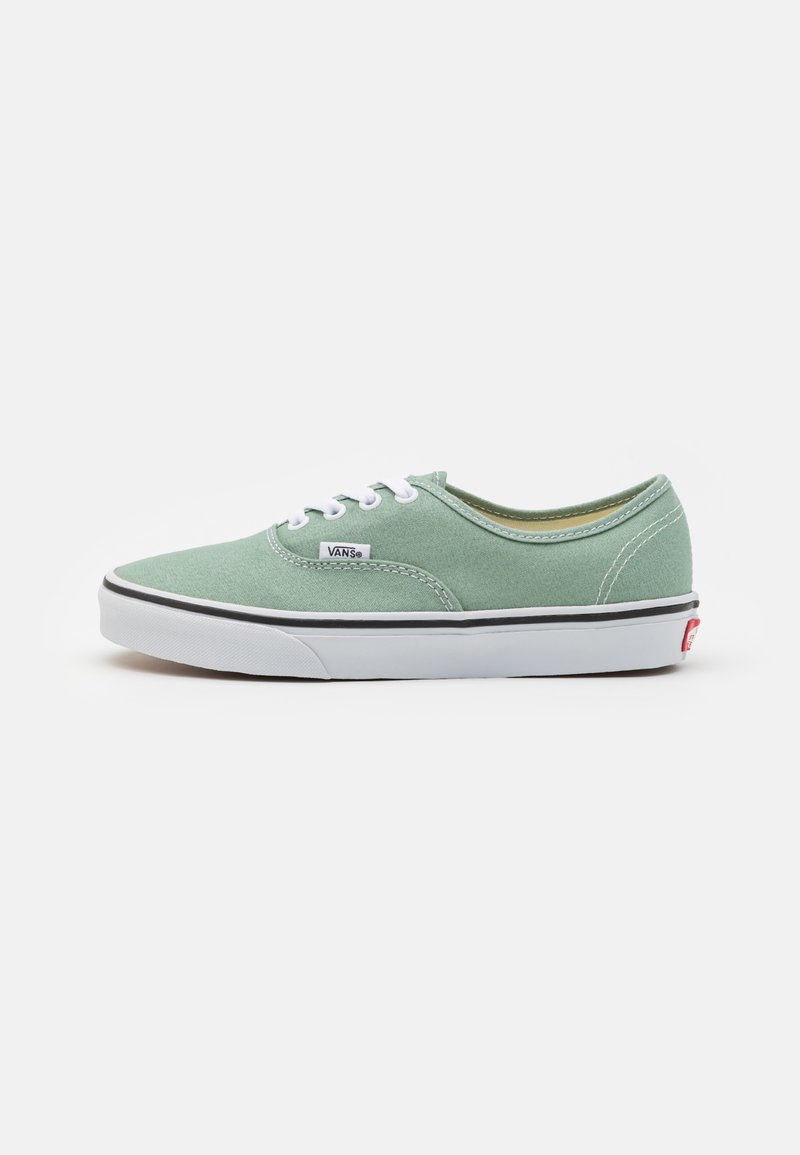 Grüne Canvas-Sneaker mit niedriger Schnittform, weißen Schnürsenkeln und Gummisohle; mit schwarzem Streifen und Vans-Logo an der Seite.