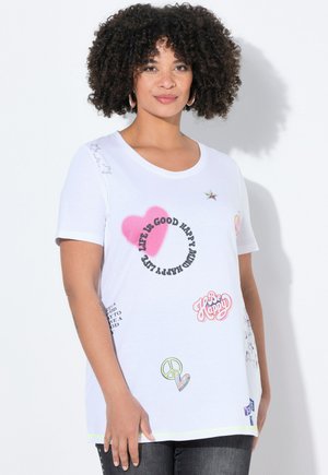 T-shirt blanc en coton à manches courtes présentant divers graphismes imprimés, y compris des cœurs, des étoiles et des phrases textuelles dans plusieurs couleurs.