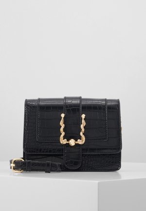 Sort faux krokodilleder crossbody taske med en gylden snoet hardwarelås, rektangulær form og justerbar rem.