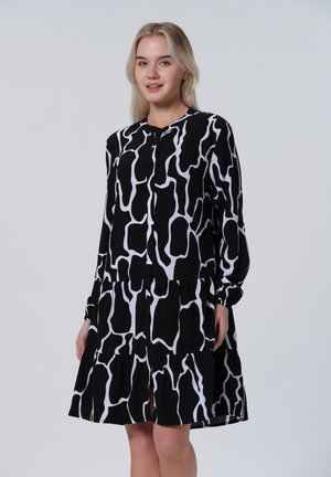 Zwart-wit mid-length jurk met een vloeiende uitstraling, lange mouwen en een abstract patroon met een gelaagde rok.