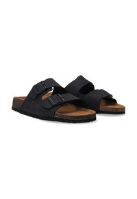 Sorte sandaler med to stropper og justerbare spænder, korkfodbed og struktureret gummisål; minimalistisk design med åben tå og hæl.