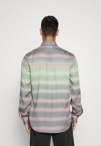 Camisa de manga larga en tela gris con rayas horizontales en tonos verdes y rosas. Cuello clásico con puños abotonados y detalle de canesú trasero.