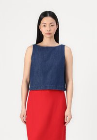 Donkerblauwe denim crop top met een ronde halslijn en mouwloos ontwerp, gecombineerd met een lange rode rok. Eenvoudige stiksel details langs de zoom.