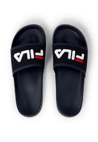 Marinblåa slide-sandaler med ett strukturerat rem som har vit och röd FILA-logotyp. Slät fotbädd och öppen tådesign. Tunn, minimalistisk form.