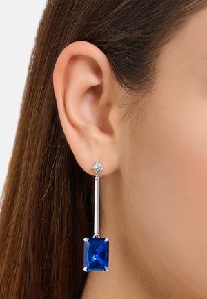 Blaue rechteckige Ohrringe mit einem silbernen metallischen Akzent und einem klaren oberen Edelstein. Sie besitzen ein langes, hängendes Design mit geometrischen Formen.