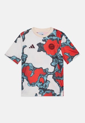 Kortærmet atletisk skjorte med en hvid bund og et rød-blåt abstrakt mønster, Adidas-logo og et rundt logo centralt på brystet.