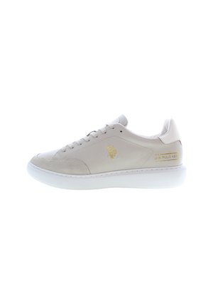 Light beige sneaker made of leather and suede with a white sole. Features lace-up design and gold logo accent on the side.