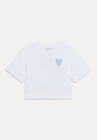 Λευκό κοντό t-shirt από βαμβάκι, με ένα ανοιχτό μπλε καρδιά με χαμογελαστό πρόσωπο στο αριστερό μέρος του στήθους. Κοντά μανίκια.