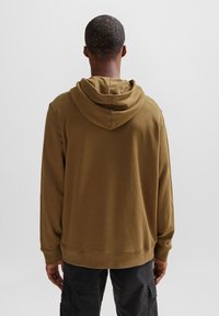 Felpa con cappuccio marrone dal taglio rilassato, con un design semplice, maniche lunghe e dettagli cuciti all'orlo e ai polsini.