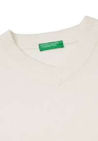 Cremefarbener Pullover mit V-Ausschnitt, geripptem Kragen und gewebter Textur. Verfügt über ein grünes Etikett mit "UNITED COLORS OF BENETTON."