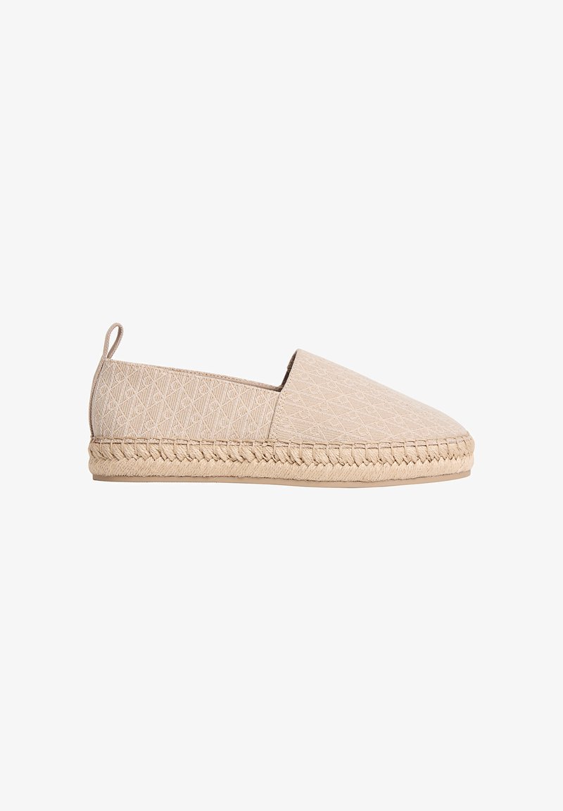 Espadrille beige à enfiler avec tige en tissu texturé, semelle intermédiaire en jute tressé, semelle plate en caoutchouc et languette de traction au talon.
