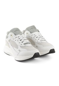 Witte sneakers met een gestructureerde mesh bovenkant, grijze suede accenten en een zwarte rubberen zool. Heeft een vetersluiting en een gevoerd kraagje.