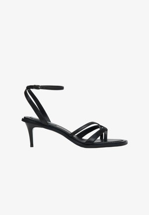 Black strappy heeled sandals with a slender ankle strap, open-toe design, and a low kitten heel; made from smooth leather with a flat sole.