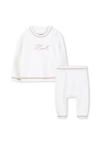 Witte gebreide outfit bestaande uit een longsleeve top met gouden borduursels en crème accenten, gecombineerd met bijpassende broek met elastische manchetten.