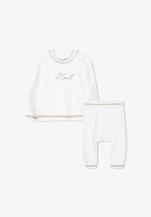 Ensemble en tricot blanc composé d'un haut à manches longues avec broderies dorées et accents crème, associé à un pantalon assorti avec des poignets élastiques.