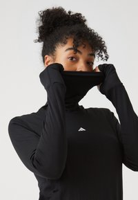 Schwarzes, langärmeliges Sportoberteil mit hohem Kragen, Daumenl�öchern in den Ärmeln und einem kleinen weißen Logo auf der Brust. Glattes, dehnbares Material.