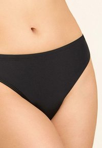 Czarny dół bikini wykonany z gładkiego materiału. Charakteryzuje się klasycznym niskim krojem, czystymi krawędziami i minimalistycznymi detalami.