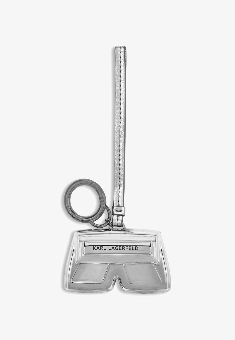 Zilveren metalen sleutelhanger in de vorm van shorts, met de naam "KARL LAGERFELD" gegraveerd. Gladde textuur met een lus voor sleutels.