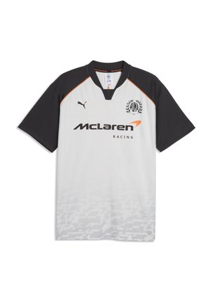 Maglia McLaren Racing a maniche corte bianca e nera con logo Puma, maniche nere, accenti arancioni e motivo geometrico sottile nella parte inferiore.
