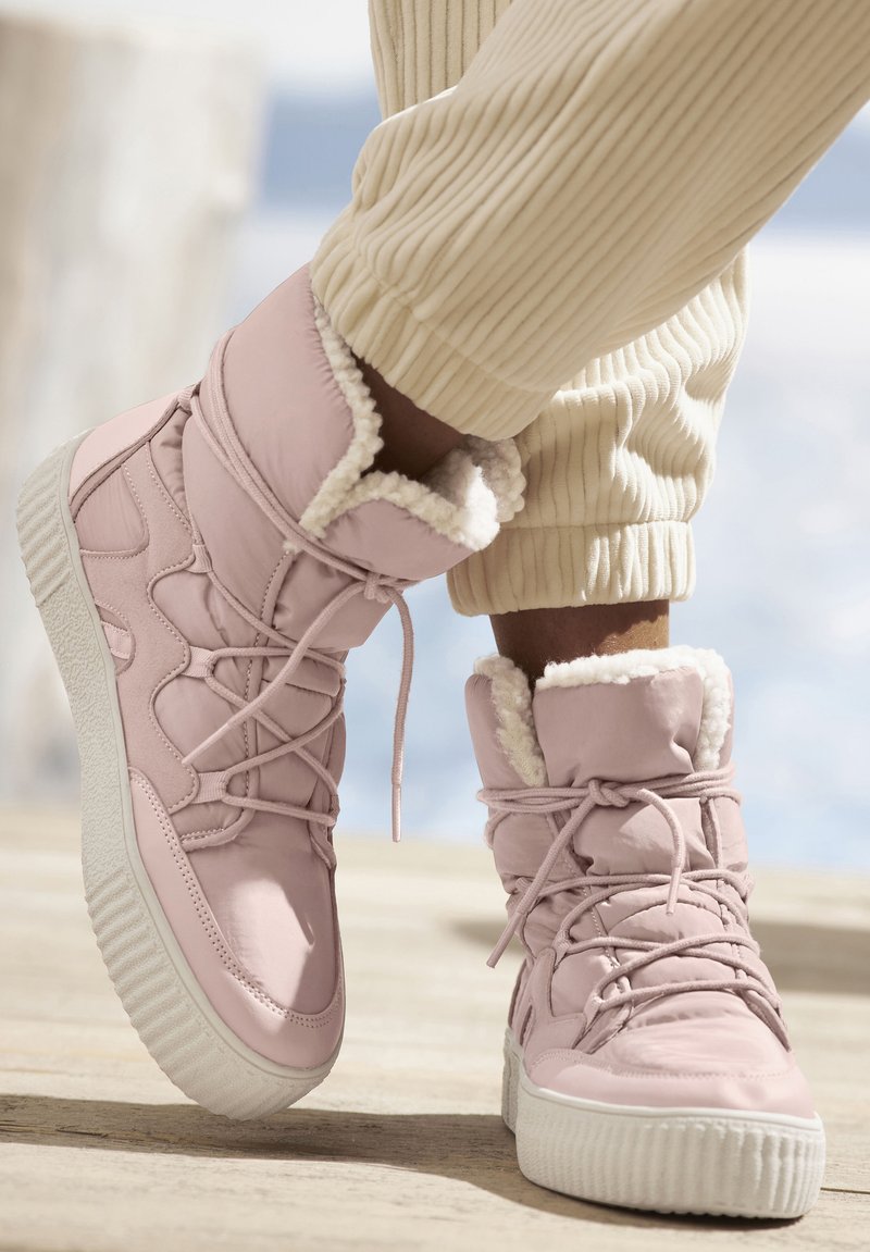 Rosa isolierte Stiefel mit Kunstfellfutter, gepolstertem Kragen und weißer Gummisohle. Sie verfügen über Schnürsenkel und ein strukturiertes Design an der Seite.