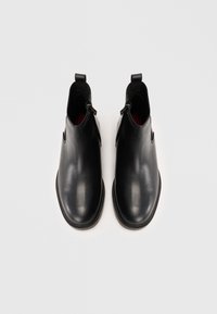 Czarne skórzane buty chelsea o gładkim wykończeniu, z zamkiem błyskawicznym i kontrastującym czerwonym wnętrzem. Solidna podeszwa i zaokrąglony design noska.