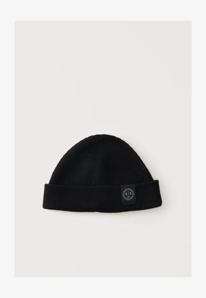 Berretto a maglia nero a coste con bordo ripiegato e una piccola toppa rotonda con logo bianco e nero sul risvolto.
