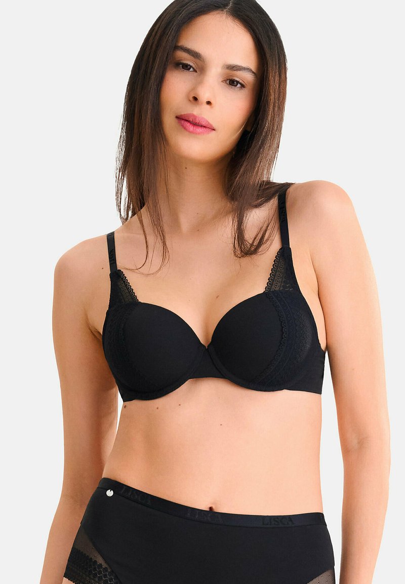 Soutien-gorge noir rembourré avec des accents en dentelle, bretelles réglables, bonnets lisses et une conception sans couture. Accompagné de culottes taille haute assorties.