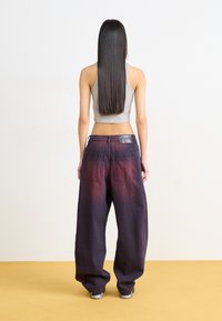 Baggy denim pants featuring a gradient from dark purple to lighter shades, with a textured back pocket and a black leather patch on the waistband.
