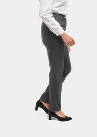 Graue, maßgeschneiderte Hosen mit geradem Bein, aus strukturiertem Stoff, kombiniert mit schwarzen, hochhackigen Schuhen. Dazu wird ein weißes Hemd eingeführt getragen.