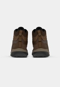 Brown hiking boots with a textured upper, padded collar, and pull tabs; featuring a thick black outsole and reinforced fabric accents.