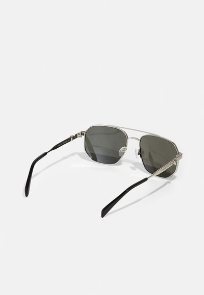 Sunglasses with a silver metal frame, octagonal lenses, gray tinted glasses, and black plastic temple arms. Includes nose pads and hinge detailing.
