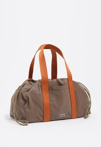 Bolso de nailon marrón con correas naranjas y cordón plateado. Presenta un diseño fruncido en la parte superior y un logotipo en el lateral, ofreciendo un diseño compacto.
