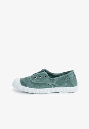 Grøn canvas slip-on sneaker med hvid gummisål og tåhætte, metalknapper og lavt snit.