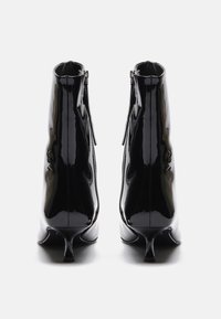 Svarte lakk lær ankel støvler med en slank hæl, med et strømlinjeformet design og sideskatter. Glatt tekstur med shiny finish.
