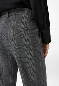 Grau karierte Hose aus strukturiertem Stoff, mit schlankem Design, einer Gesäßtasche und dezentem Logo-Detail am Bund.