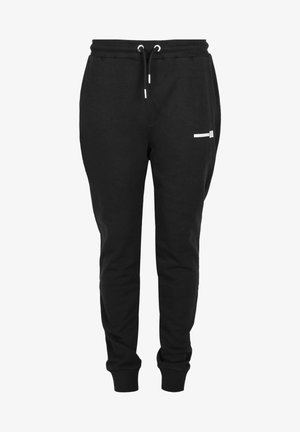 Černé joggingové kalhoty vyrobené z měkké látky, s elastickým pasem na šňůrku, žebrovanými manžetami a malou bílou kapsou na stehně.