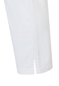 Witte katoenen shirt met een rechte snit, korte mouwen en zijsplitten aan de zoom. Glad textuur met schone naden en geen versieringen.