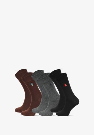 Zestaw bawełnianych skarpet w kolorach brązowym, szarym i czarnym. Każda posiada kontrastowe, haftowane logo. Gładka faktura oraz długość do połowy łydki.