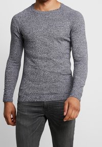 Langärmliges Rundhals-T-Shirt aus strukturiertem grauen Strick, mit einer taillierten Silhouette und glattem Stoff mit dezenten Mustern.