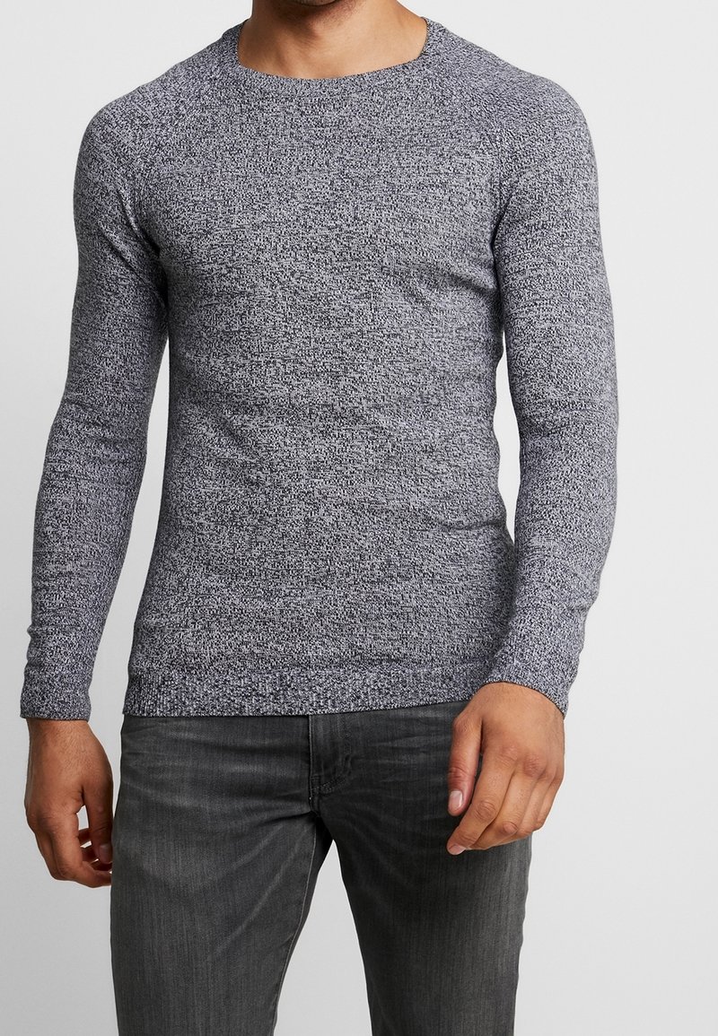 Langärmliges Rundhals-T-Shirt aus strukturiertem grauen Strick, mit einer taillierten Silhouette und glattem Stoff mit dezenten Mustern.