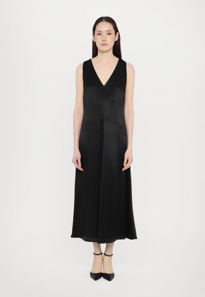 Abito nero senza maniche con scollatura a V, realizzato in tessuto liscio, forma a trapezio, che arriva sotto il ginocchio, caratterizzato da un design minimalista e senza modelli.
